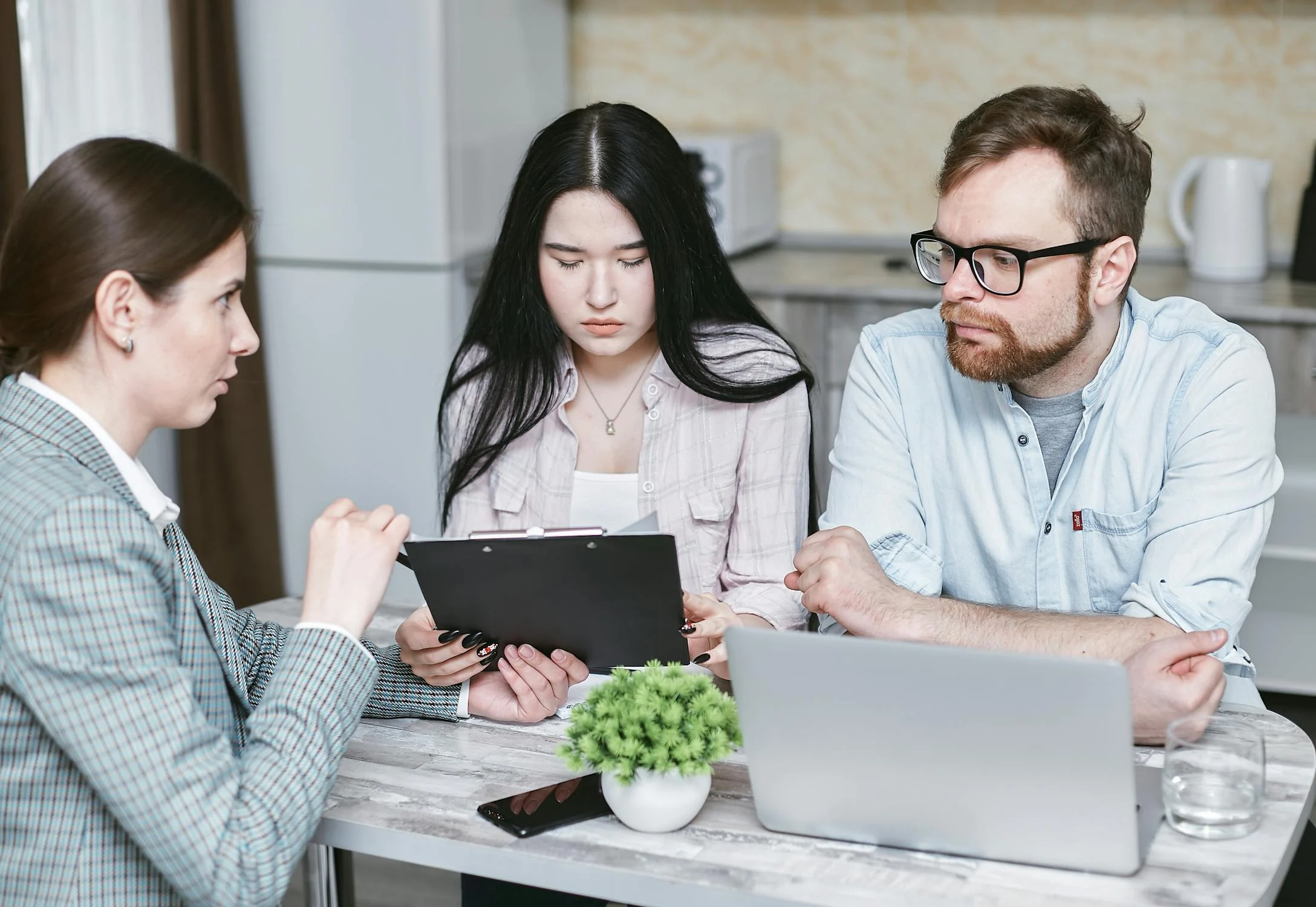 Business owner and employee reviewing documents together at a desk, representing the onboarding and payroll process.